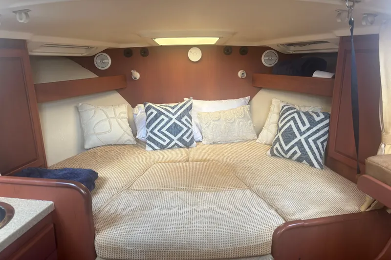 Slide: The Image of 2004 Luhrs 32 Open cabin interior with cozy bedding and decorative pillows. - 24