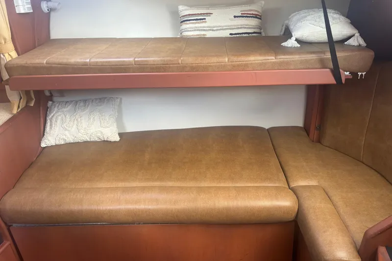 Slide: The Image of 2004 Luhrs 32 Open cabin interior with brown leather bunks and decorative pillows. - 27