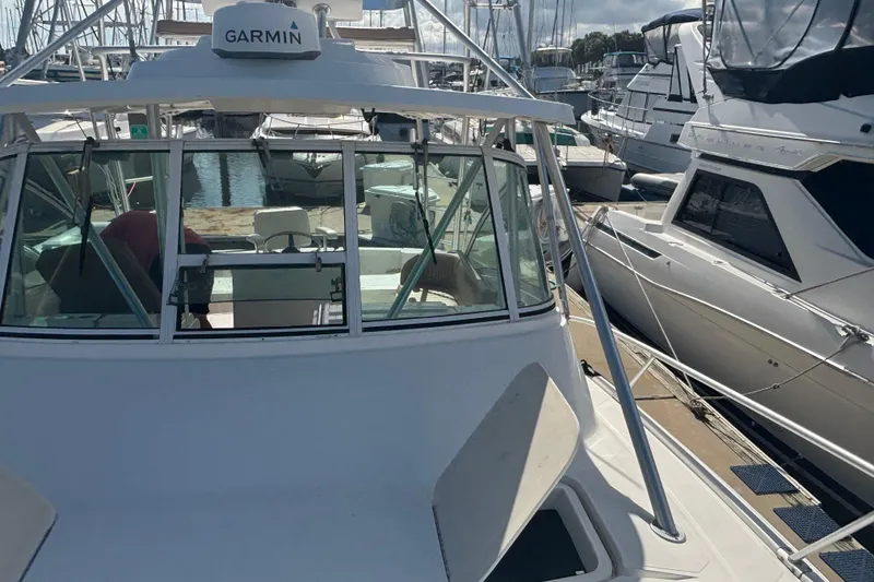 Slide: The Image of 2004 Luhrs 32 Open boat docked at marina, featuring Garmin equipment. - 3
