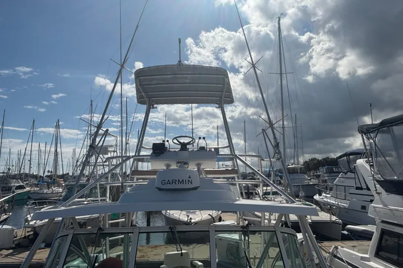 Slide: The Image of 2004 Luhrs 32 Open boat docked at marina under cloudy sky. - 4