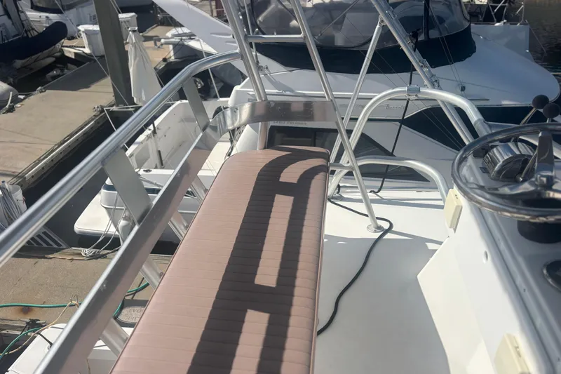 Slide: The Image of 2004 Luhrs 32 Open boat deck with steering wheel and seating at marina. - 7