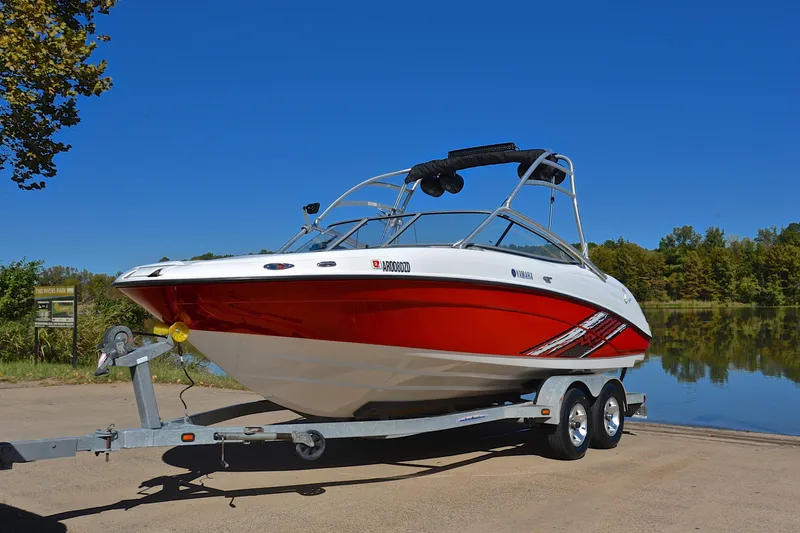 Slide: The Image of 2008 Yamaha AR210 boat on trailer by a lake, under clear blue sky. - 11