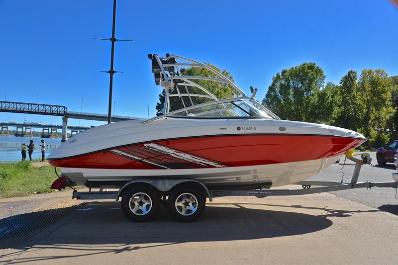 Slide: The Image of 2008 Yamaha Boats AR210 on trailer by riverside, sunny day, trees and bridge in background. - 16