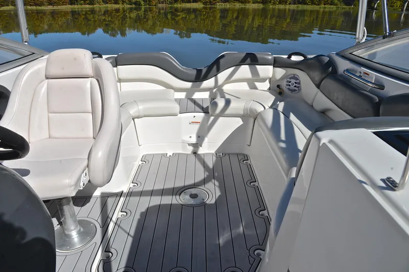 Slide: The Image of 2008 Yamaha Boats AR210 interior with seating and steering, on calm water. - 23