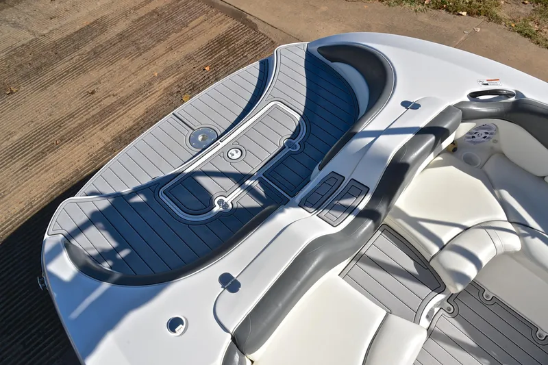 Slide: The Image of 2008 Yamaha AR210 boat interior with gray and white seating and deck. - 24
