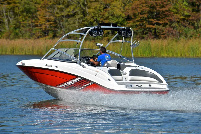 Slide: The Image of 2008 Yamaha AR210 boat speeding on a lake with lush greenery in the background. - 4