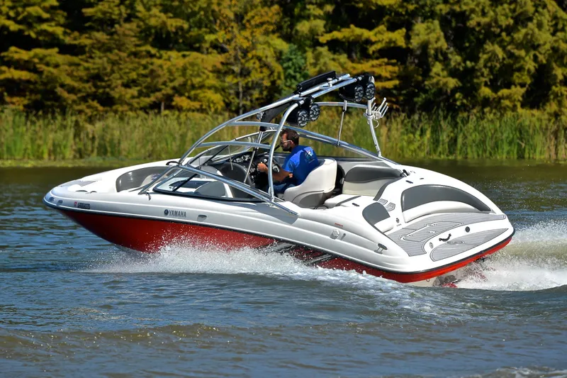 Slide: The Image of 2008 Yamaha AR210 boat cruising on a lake with lush greenery in the background. - 6