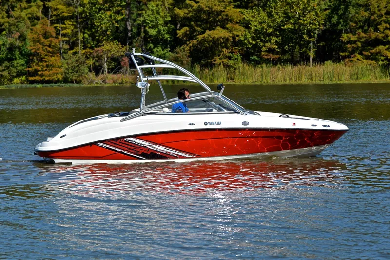 Slide: The Image of 2008 Yamaha AR210 boat cruising on a serene lake with lush green trees. - 7