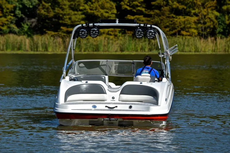 Slide: The Image of 2008 Yamaha Boats AR210 on a serene lake, rear view with lush greenery. - 9
