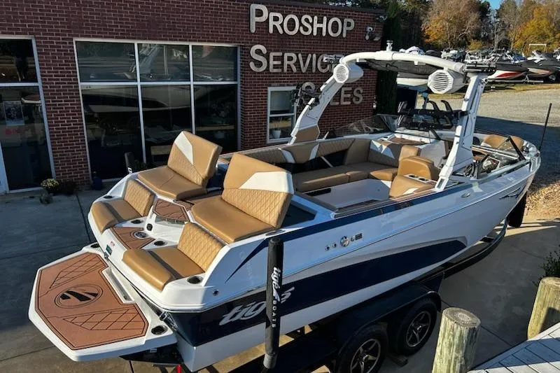 Slide: The Image of 2023 Tigé Z3 boat with tan seating, parked outside a pro shop. - 3