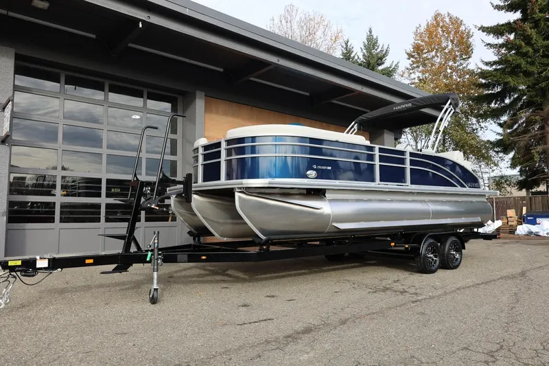 Slide: The Image of 2026 Harris CRUISER 230 SL pontoon boat on trailer, parked outdoors. - 14