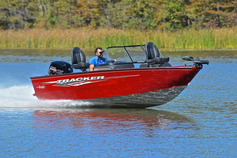 The Image of 2022 Bass Tracker Pro Guide V175 WT boat cruising on a lake with lush greenery. - 1