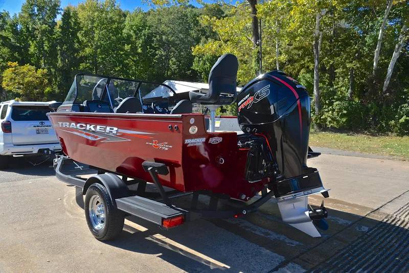 Slide: The Image of 2022 Bass Tracker Pro Guide V175 WT boat on trailer, parked near trees. - 12