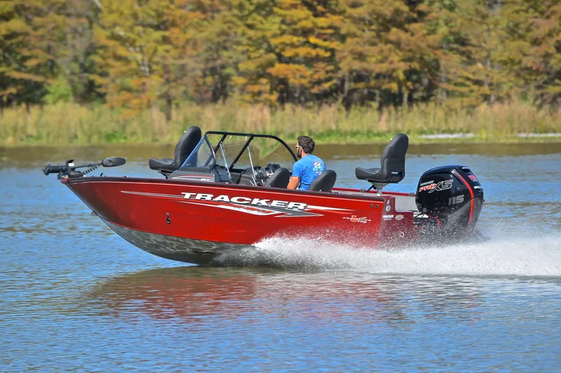Slide: The Image of 2022 Bass Tracker Pro Guide V175 WT boat speeding on a lake with trees in the background. - 4