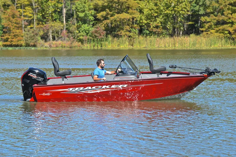 Slide: The Image of 2022 Bass Tracker Pro Guide V175 WT boat on a lake, surrounded by trees. - 7