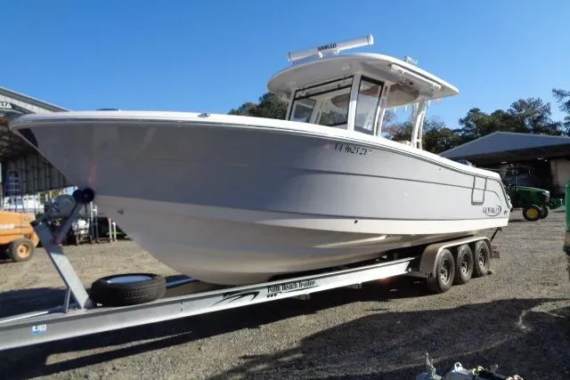 The Image of 2023 Robalo R302 Center Console boat on a trailer, parked outdoors. - 0
