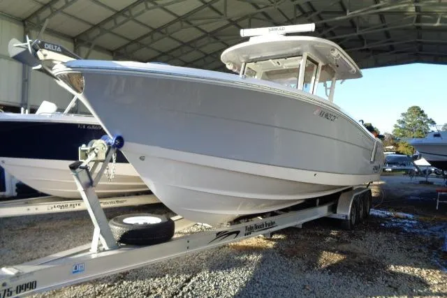 Slide: The Image of 2023 Robalo R302 Center Console boat on trailer in covered storage. - 3