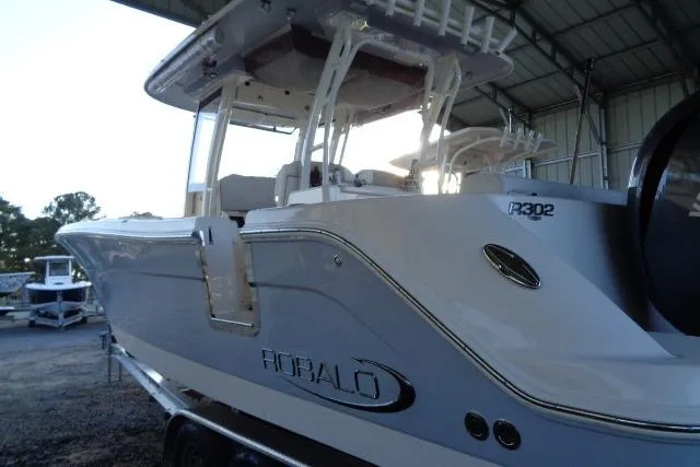 Slide: The Image of 2023 Robalo R302 Center Console boat in a covered storage area. - 7