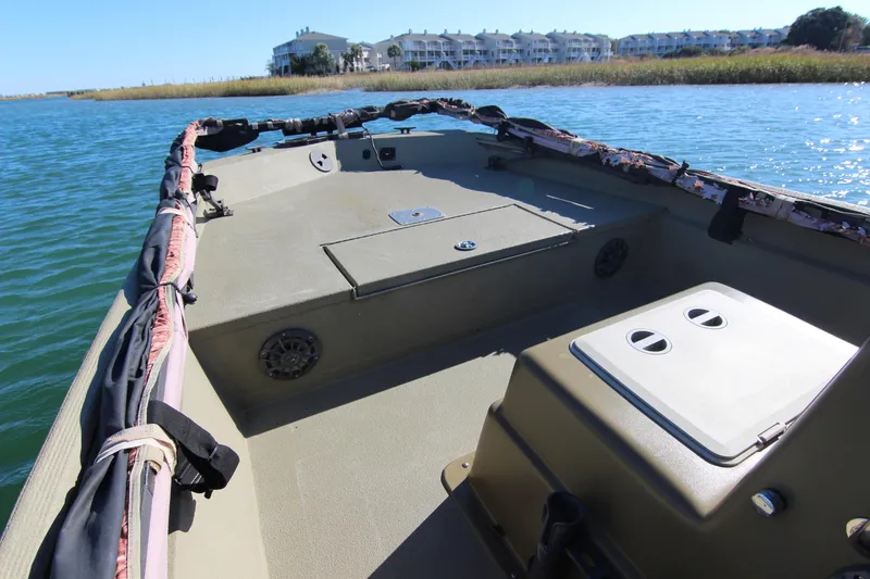 Slide: The Image of 2006 Xpress HD18CC boat on water, with residential buildings in the background. - 10