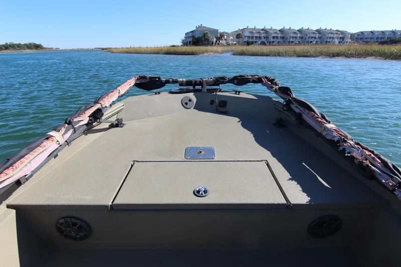 Slide: The Image of 2006 Xpress HD18CC boat on calm water near residential buildings. - 11