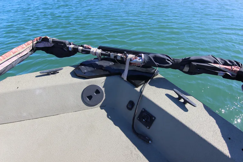 Slide: The Image of 2006 Xpress HD18CC boat deck with fishing rod holder on calm water. - 12