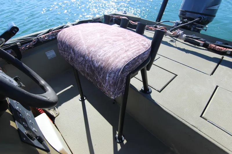 Slide: The Image of 2006 Xpress HD18CC boat interior with camo seat and steering wheel on water. - 17