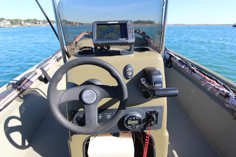Slide: The Image of Steering console of 2006 Xpress HD18CC boat with navigation system on calm water. - 19