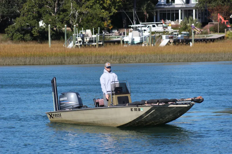 Slide: The Image of Man on 2006 Xpress HD18CC boat with Yamaha motor, cruising on a calm river. - 8
