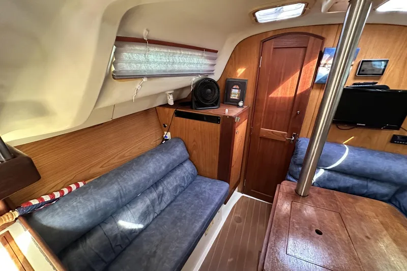 Slide: The Image of Interior of a 2000 Hunter 290 sailboat with cozy seating and wooden finishes. - 11