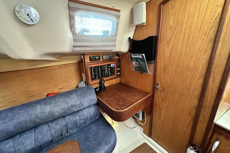 Slide: The Image of Interior of a 2000 Hunter 290 sailboat with navigation station and seating area. - 12