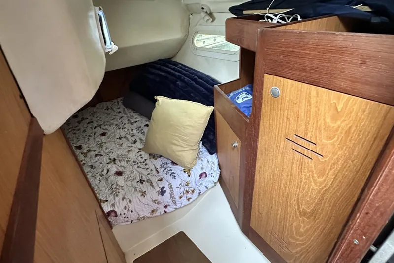 Slide: The Image of Cozy cabin interior of 2000 Hunter 290 sailboat with bed and wooden storage. - 15