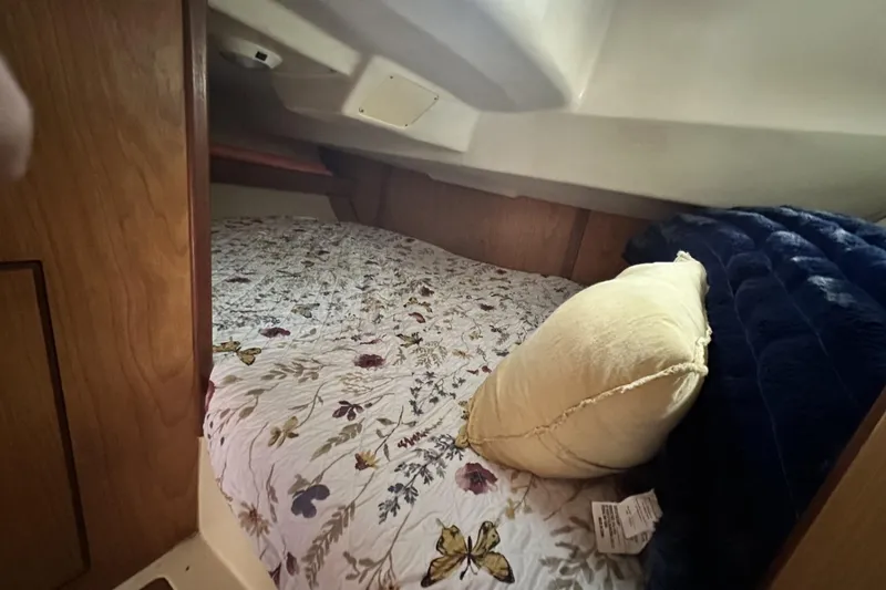 Slide: The Image of Cozy cabin interior of 2000 Hunter 290 sailboat with floral bedding and pillow. - 16