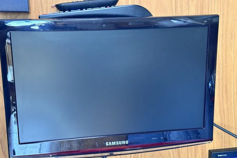 Slide: The Image of Samsung TV on wooden surface, remote control on top, Hunter 290, 2000 model. - 21