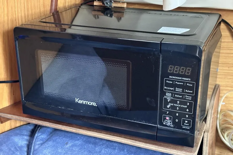 Slide: The Image of Kenmore microwave on a wooden shelf inside a 2000 Hunter 290 boat. - 23