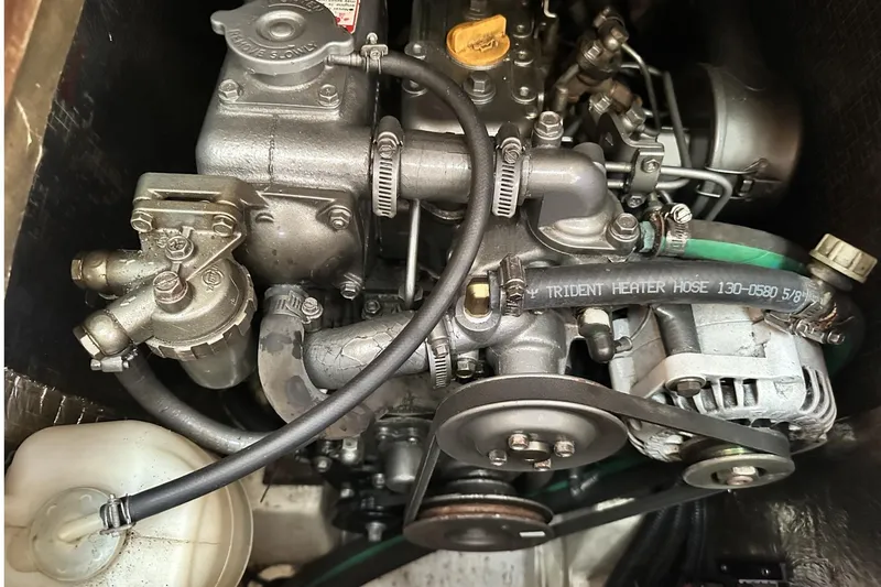 Slide: The Image of Engine of a 2000 Hunter 290 sailboat, featuring hoses and mechanical components. - 26