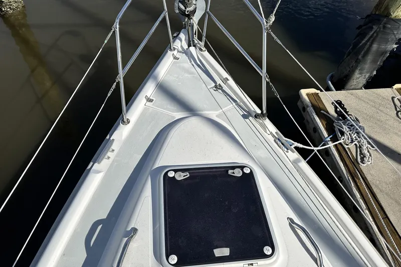 Slide: The Image of Bow of 2000 Hunter 290 sailboat docked, featuring deck hatch and railing. - 30