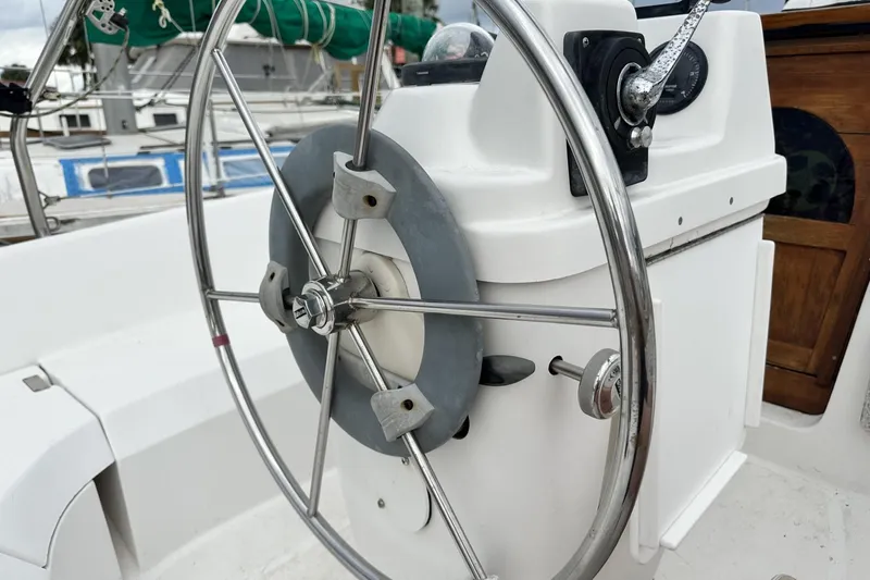 Slide: The Image of Steering wheel of a 2000 Hunter 290 sailboat, featuring a stainless steel design. - 35