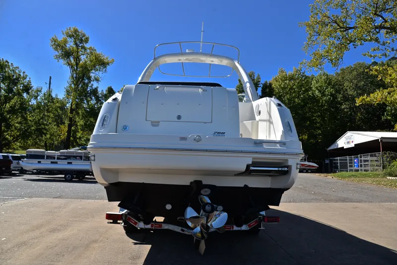 Slide: The Image of 2011 Sea Ray 260 Sundancer boat on trailer, rear view, surrounded by trees. - 14