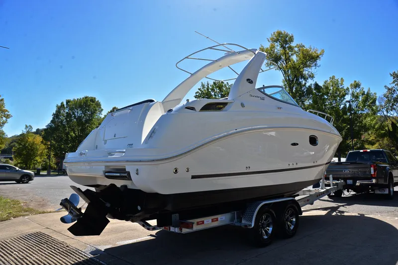 Slide: The Image of 2011 Sea Ray 260 Sundancer boat on trailer, parked outdoors under clear blue sky. - 15