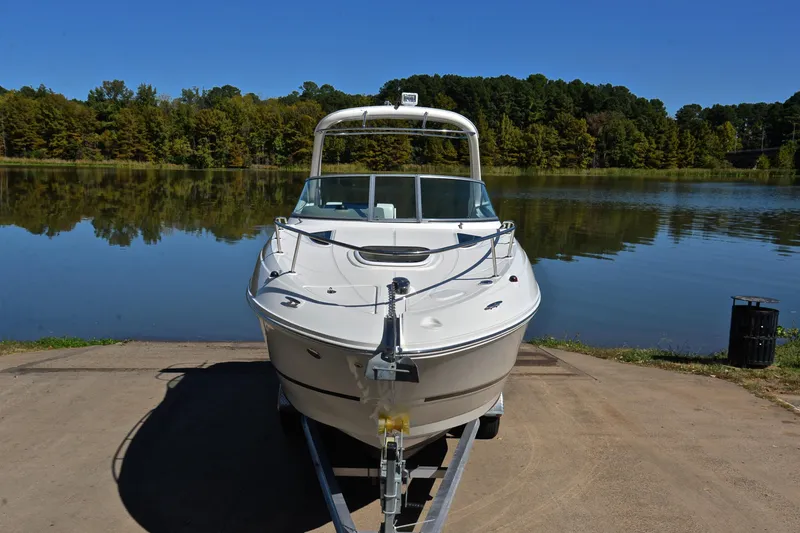 Slide: The Image of 2011 Sea Ray 260 Sundancer boat on trailer by a serene lake. - 18