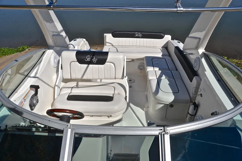 Slide: The Image of 2011 Sea Ray 260 Sundancer boat interior with white seating and steering wheel. - 25