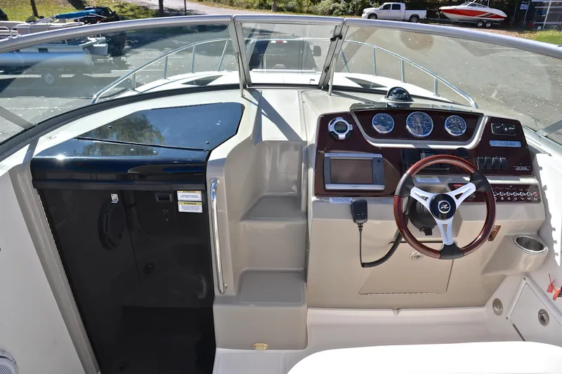 Slide: The Image of 2011 Sea Ray 260 Sundancer helm with steering wheel, gauges, and navigation equipment. - 26