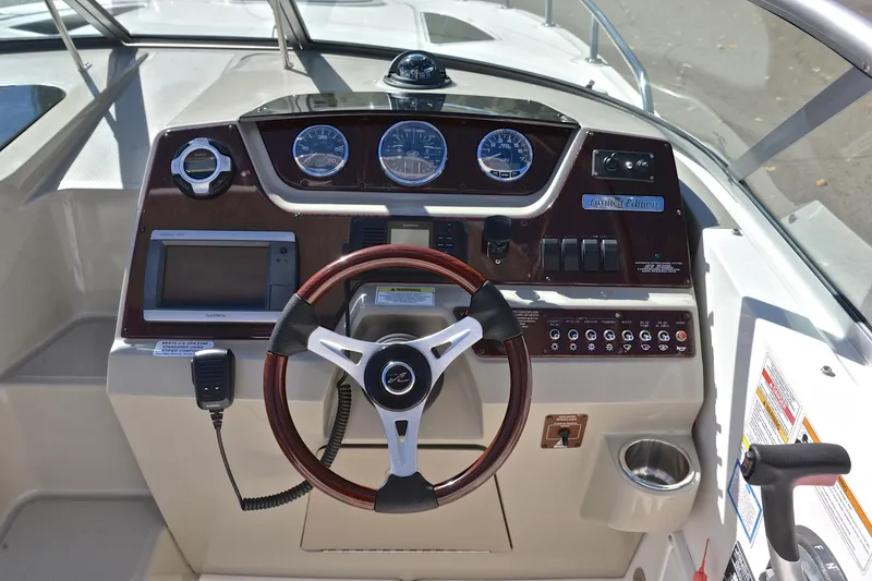 Slide: The Image of 2011 Sea Ray 260 Sundancer dashboard with steering wheel and navigation controls. - 27