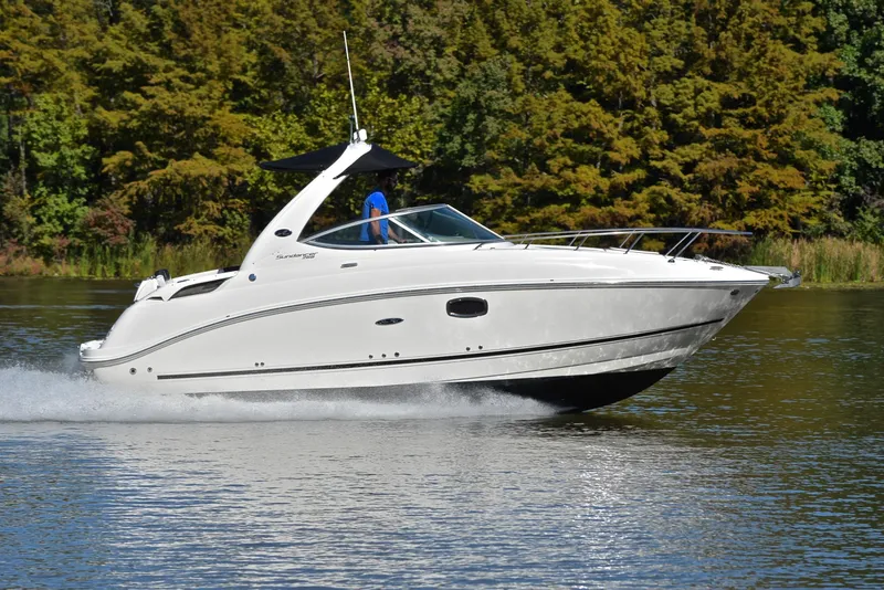 Slide: The Image of 2011 Sea Ray 260 Sundancer cruising on a serene lake with lush green trees. - 3