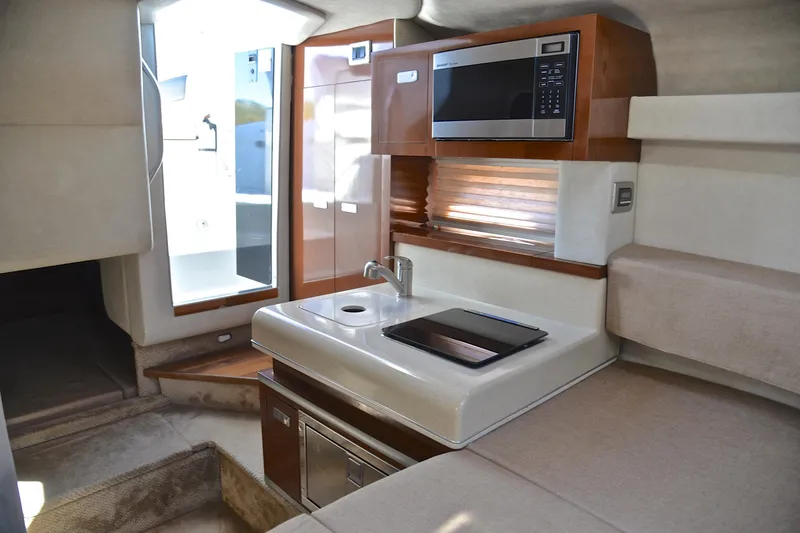 Slide: The Image of Interior of 2011 Sea Ray 260 Sundancer boat with kitchenette and seating area. - 33