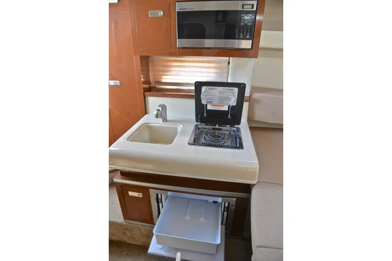 Slide: The Image of Compact kitchen area in 2011 Sea Ray 260 Sundancer with sink, stove, and microwave. - 41