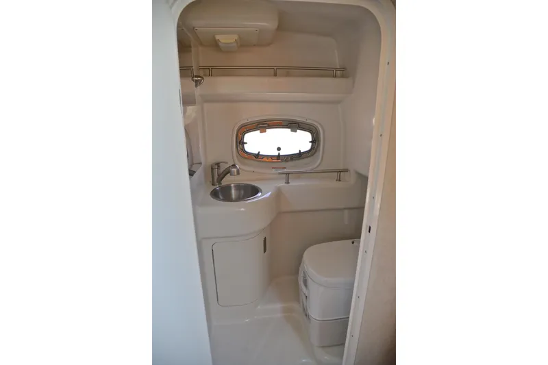 Slide: The Image of 2011 Sea Ray 260 Sundancer bathroom with sink, toilet, and porthole window. - 42