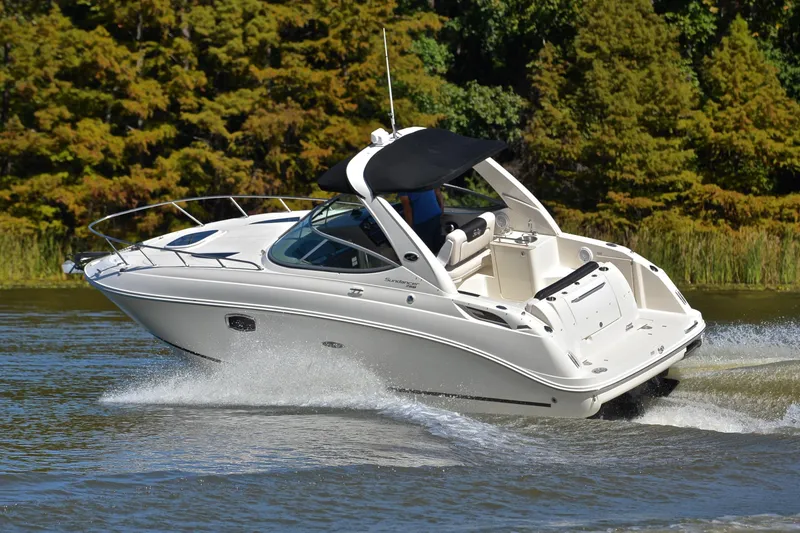 Slide: The Image of 2011 Sea Ray 260 Sundancer cruising on a scenic lake with lush greenery. - 6