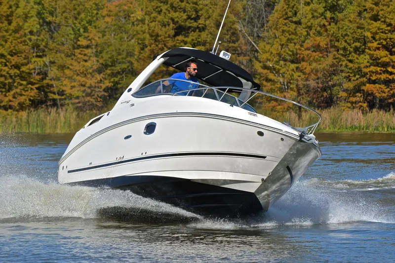 Slide: The Image of 2011 Sea Ray 260 Sundancer cruising on a scenic lake with trees in the background. - 7