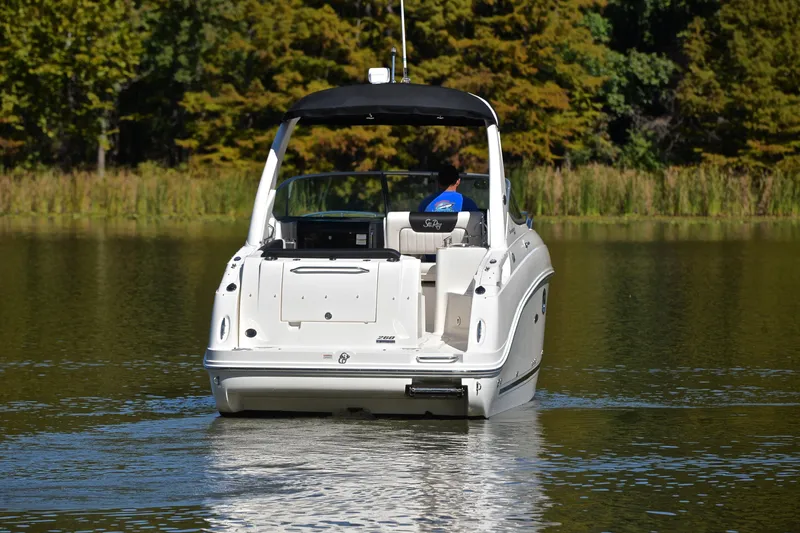 Slide: The Image of 2011 Sea Ray 260 Sundancer cruising on a serene lake with lush greenery. - 9